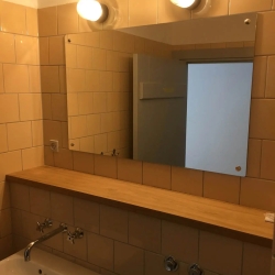 Montering af spejl på flisevæg på badeværelse