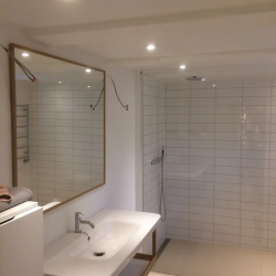 opsætning af spejl på hvidt badeværelse over vask