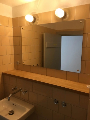 Montering af spejl på flisevæg på badeværelse