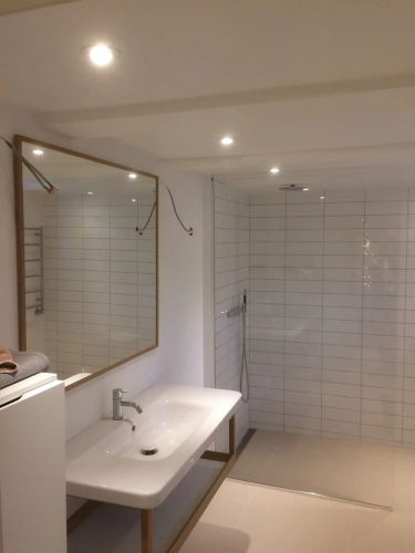 opsætning af spejl på hvidt badeværelse over vask